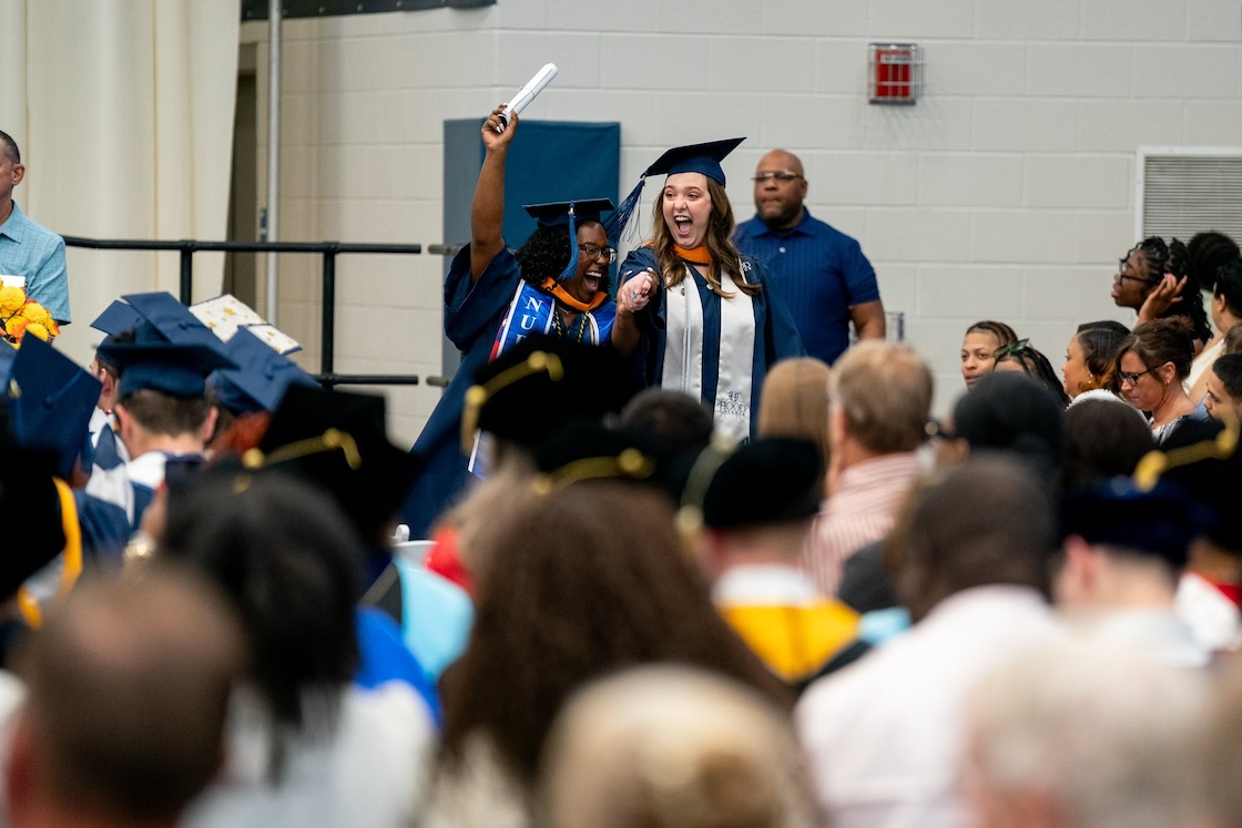 Two Hood students celebrating after receiving their diplomas.