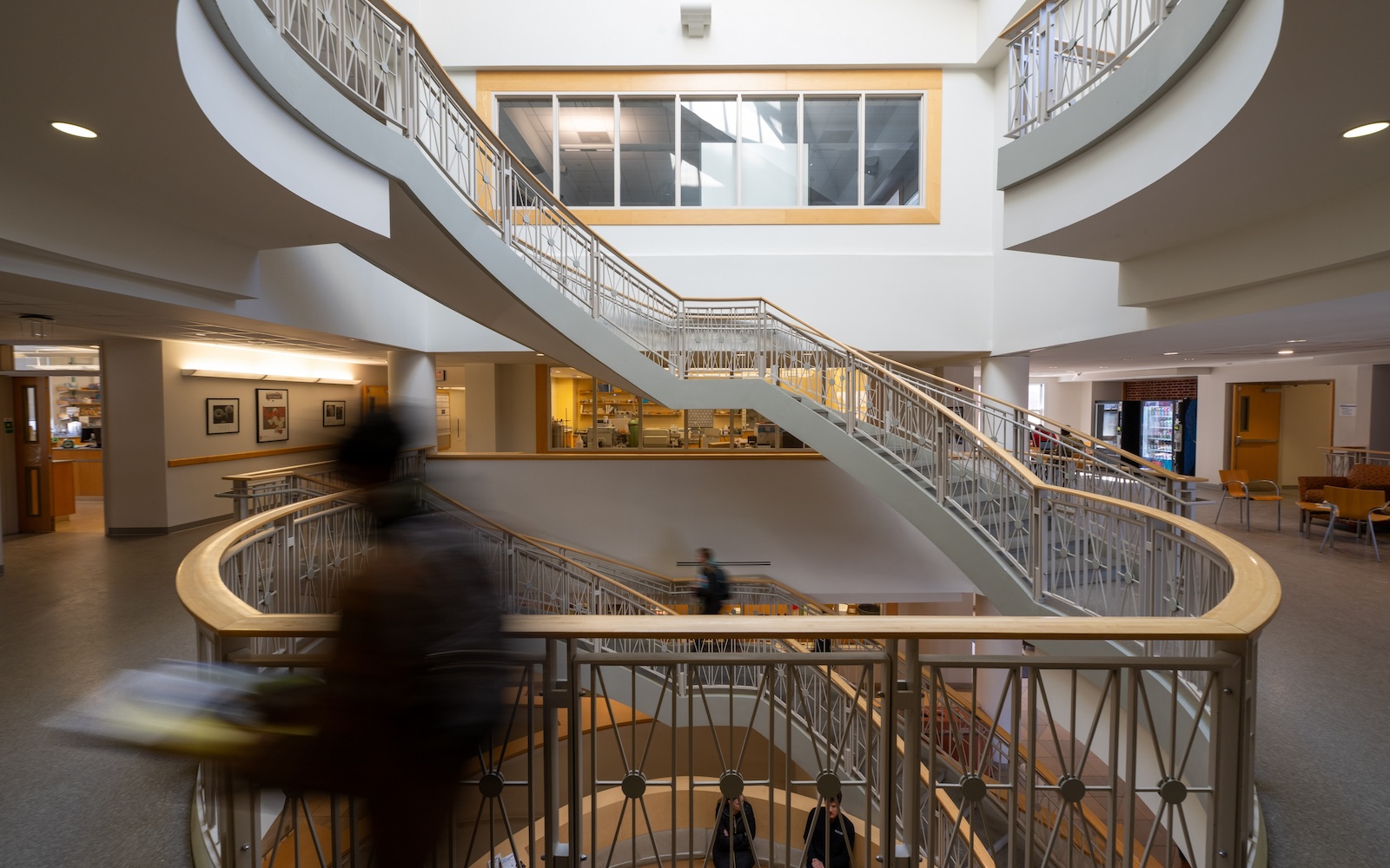 Students walk by the double helix staircase within the Hodson Science and Technology Center