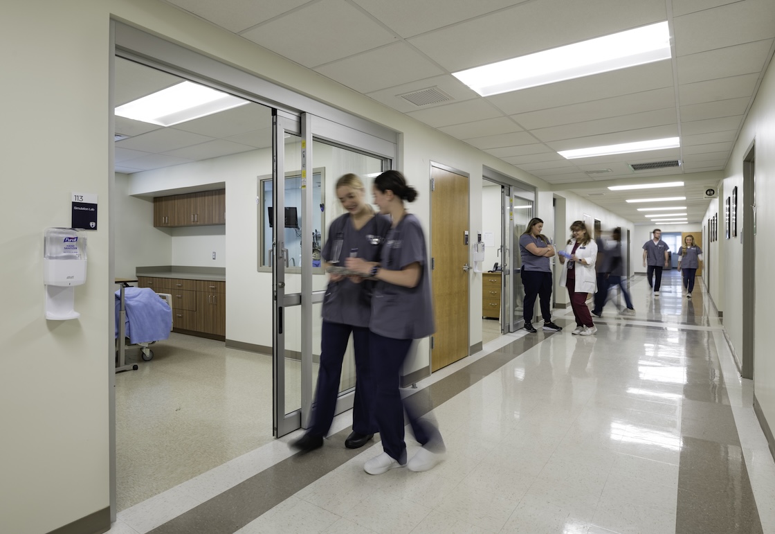 Nursing students walking past the simulation labs.