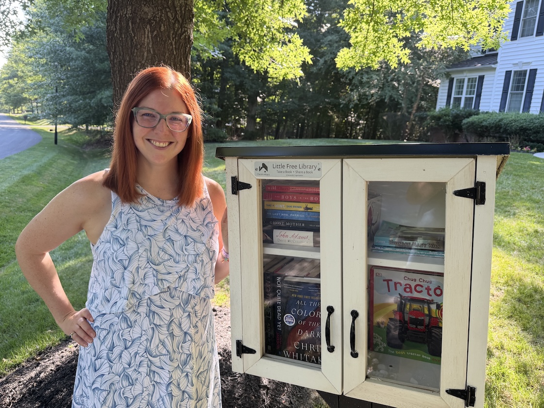 Katrina Kuhn standing in front of her Little Free Library.