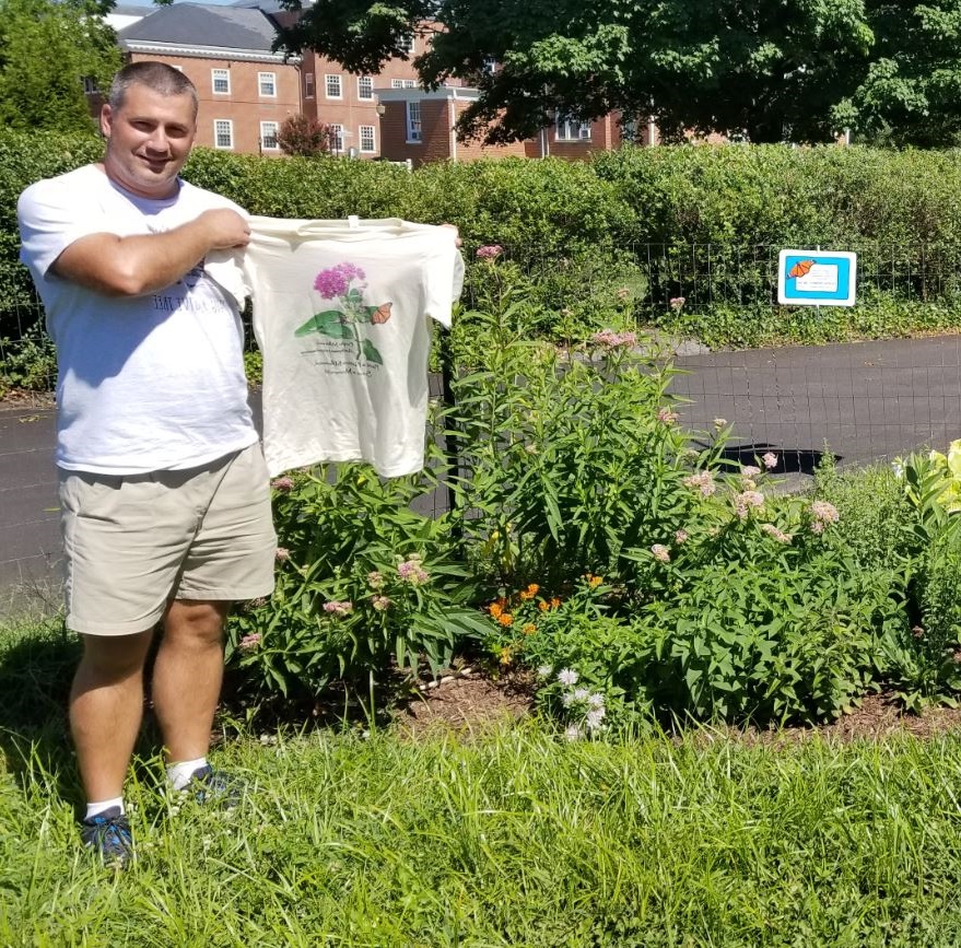 Photo of John Maciolek holding T-Shirt