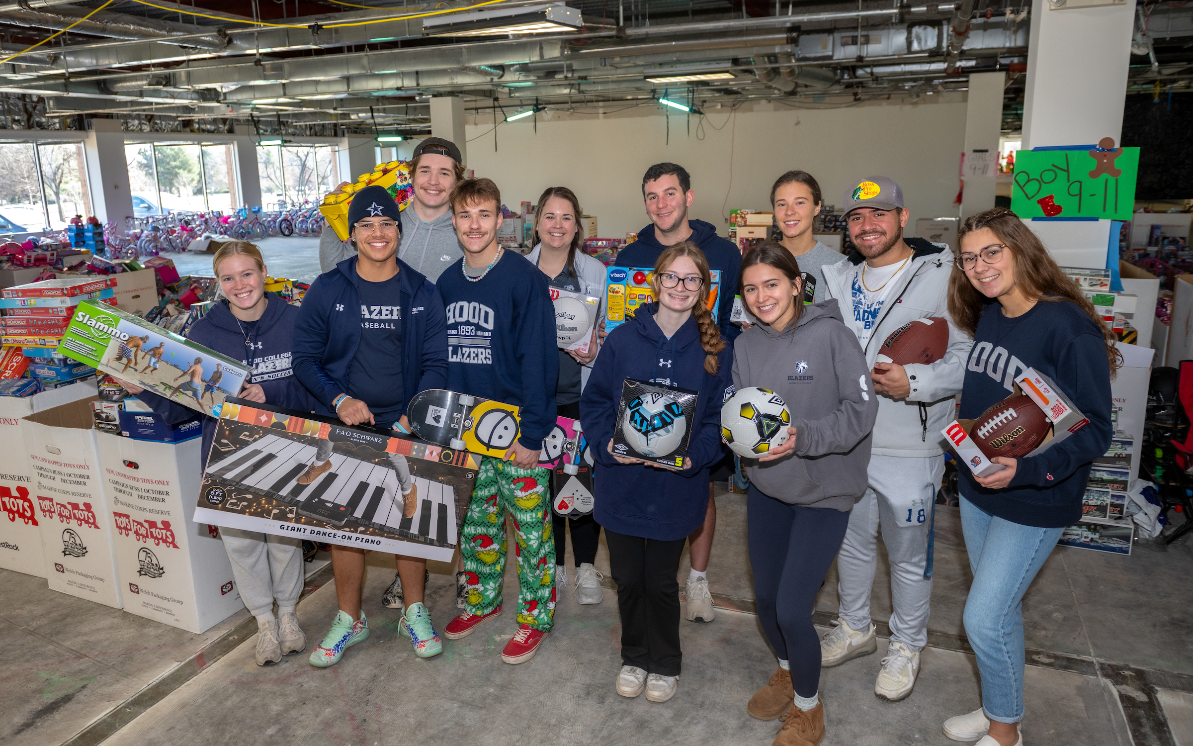 Blazer student-athletes pose with toys at the "Toys for Tots" distribution warehouse in Frederick