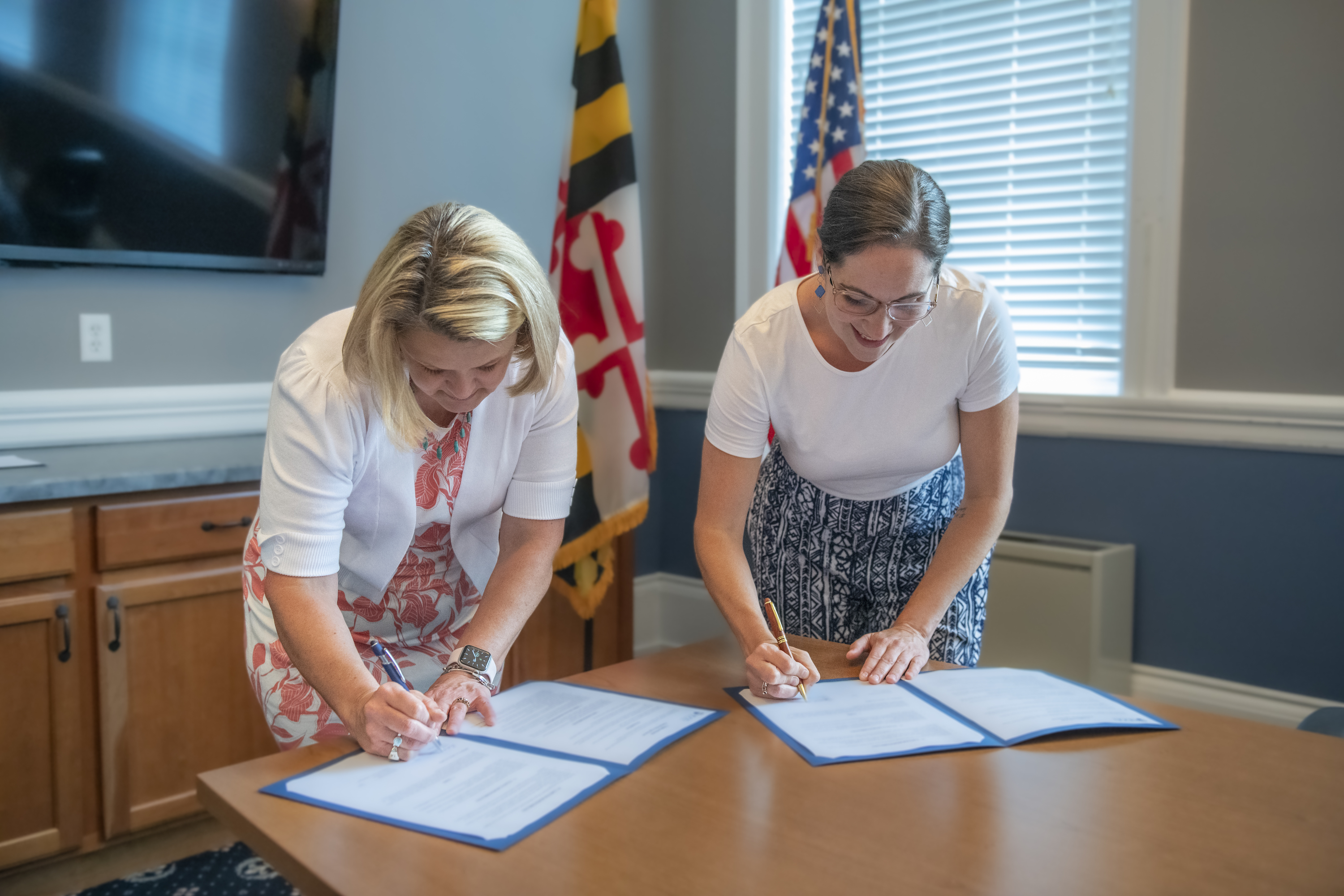 Andrea E. Chapdelaine, Ph.D., president of Hood College, and Jessica Fitzwater, M.S.'10, Frederick County executive, sign NeighborHOOD Partnership agreements
