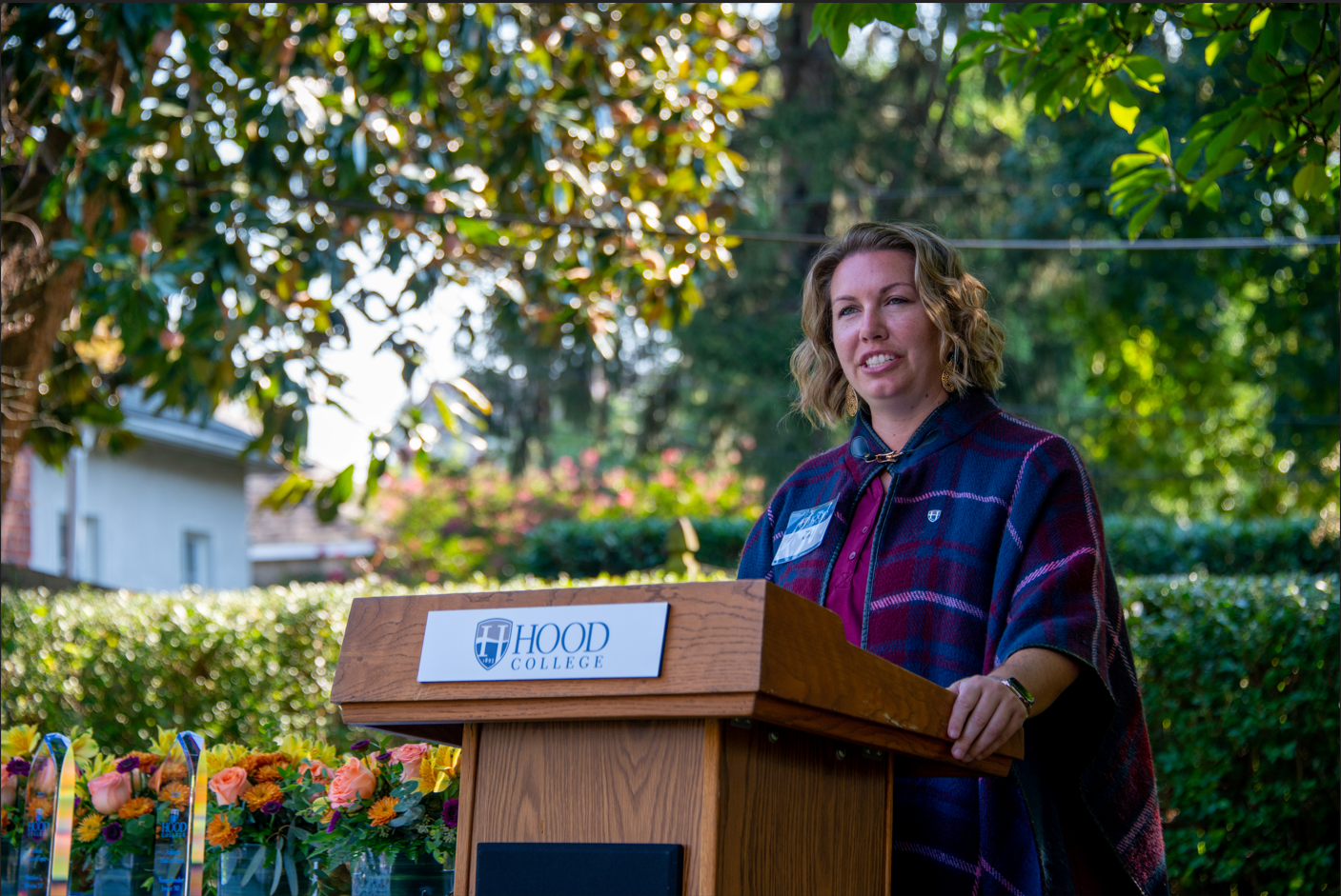 Susan Kolb standing at a podium, addressing the crowd