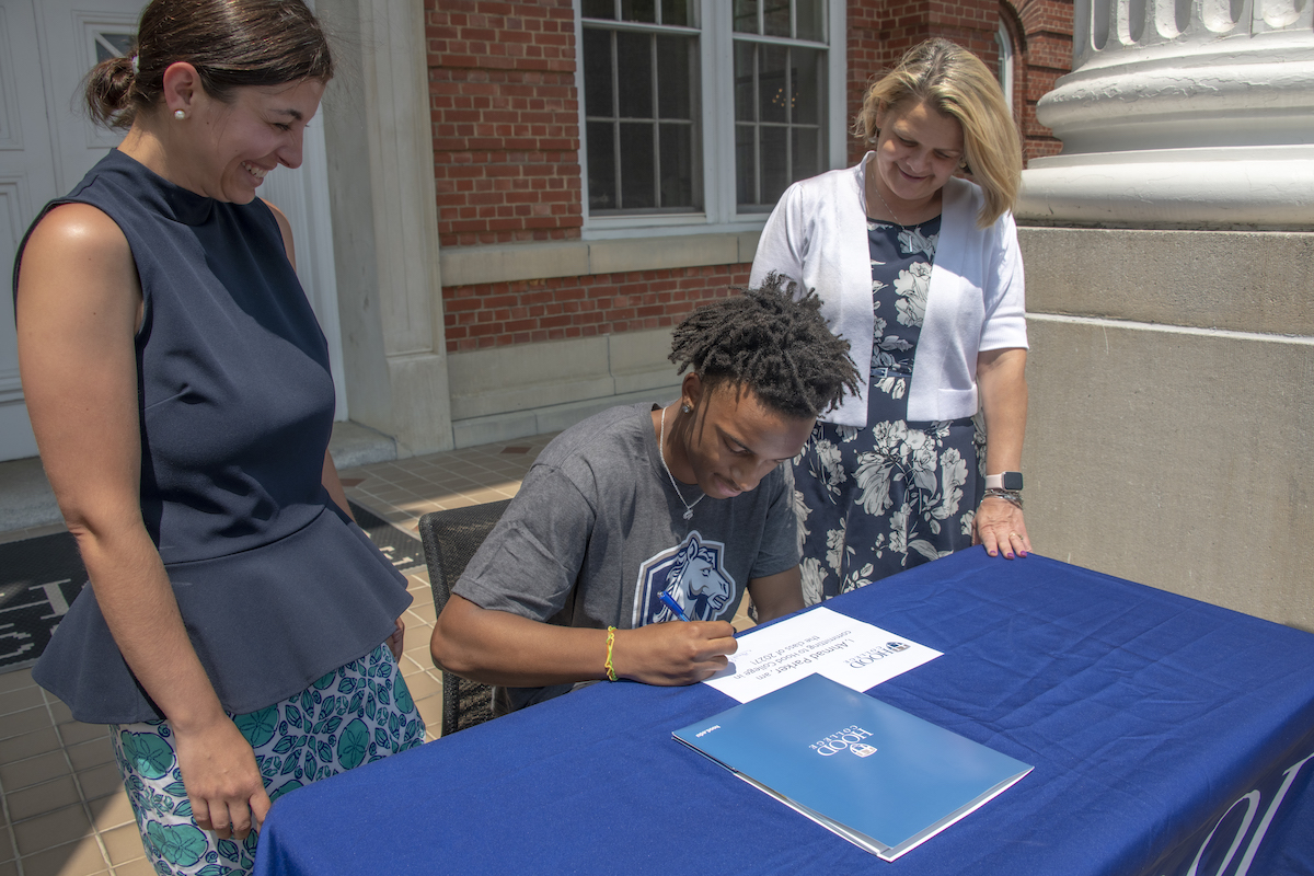 Ahmad Parker signs his commitment to Hood College.