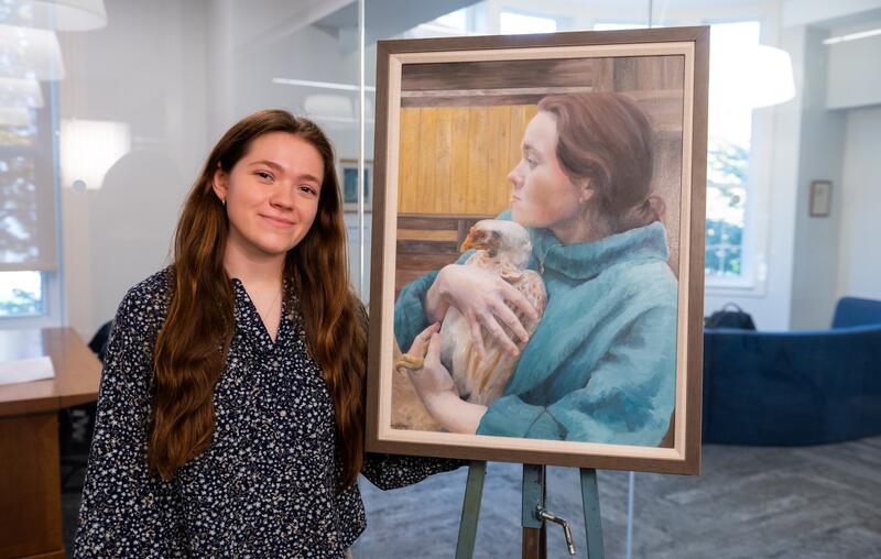 Jenny Schlossberg poses with her portrait.