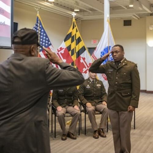 An ROTC student stands and salutes