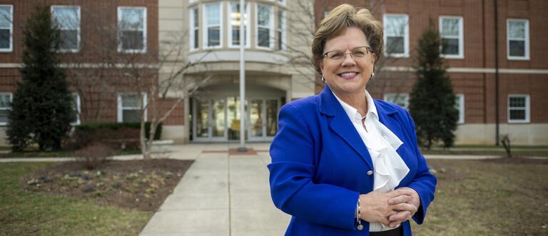 President Debbie Ricker, Ph.D. stands outside of the Beneficial-Hodson Library and Learning Commons