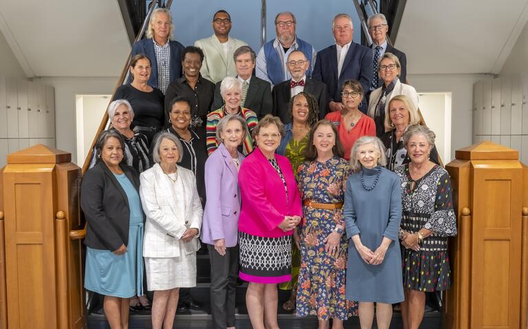 A formal photo of the Hood College Board of Trustees lined up on the stairs inside the Library and Learning Commons