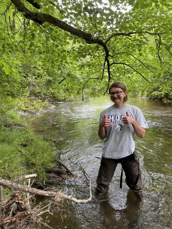 Student wearing waders in stream