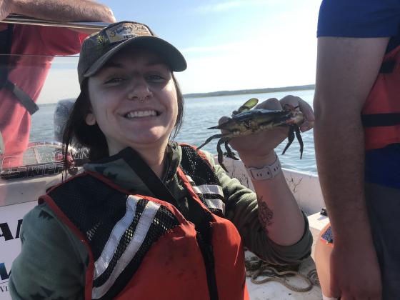 Higgins with blue crab on research vessel