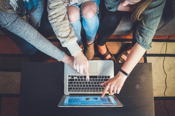 Three people around laptop