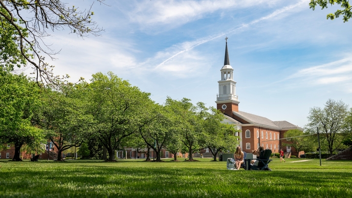 Students sit on the Residential Quadrangle in front of Coffman Chapel during the fall