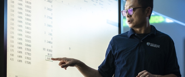 A Hood professor presenting a lecture at a whiteboard.