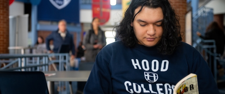 A Hood student reading a book in Whitaker Campus Center.